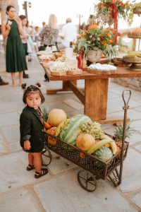 baby in front of fruit cart