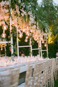 white long table with pergola full of orchirds
